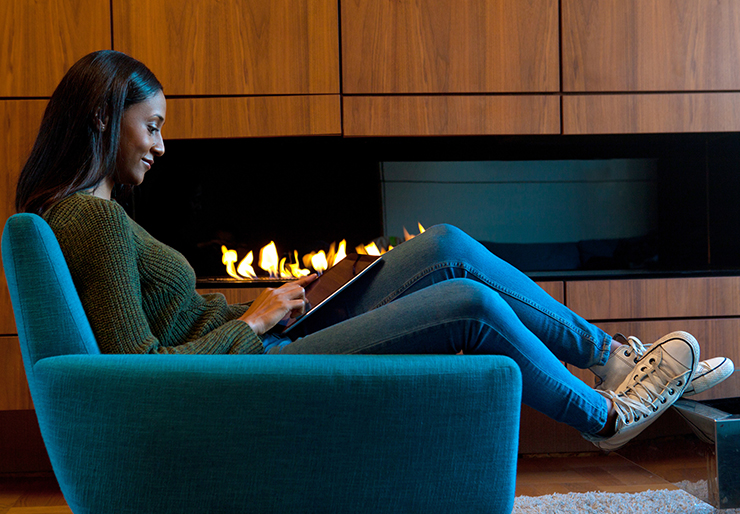 Female reading in front of a gas fireplace