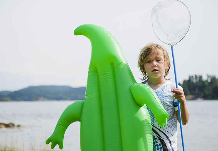 Young boy holding an inflatable crocodile
