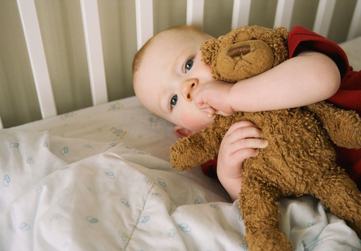 Bilde av barn med bamse i seng