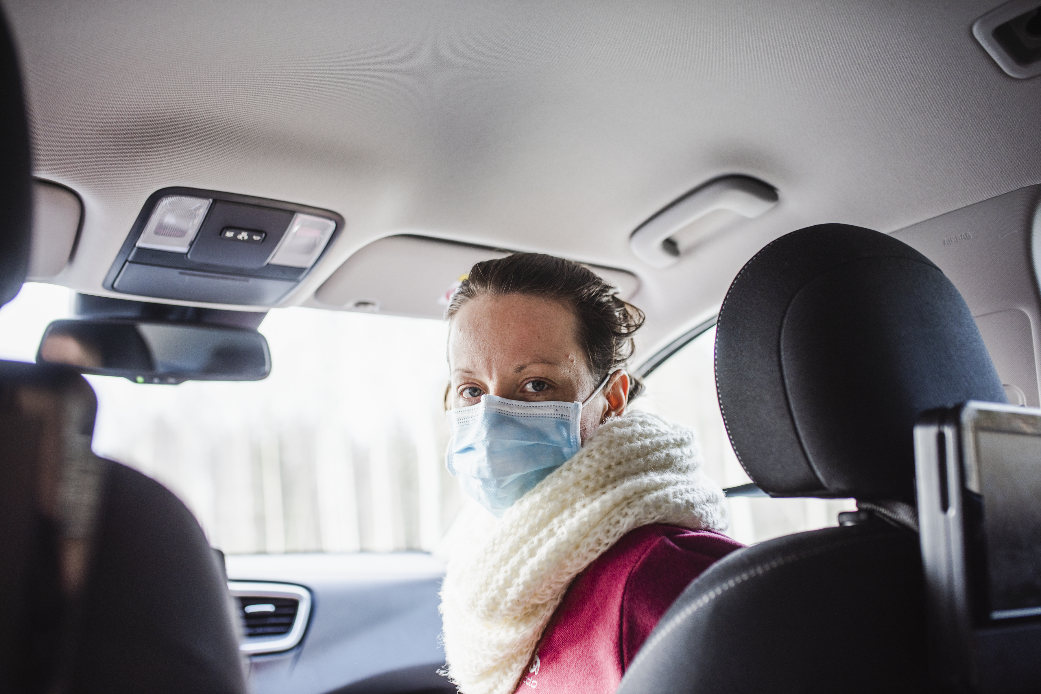 Woman in car wearing face mask